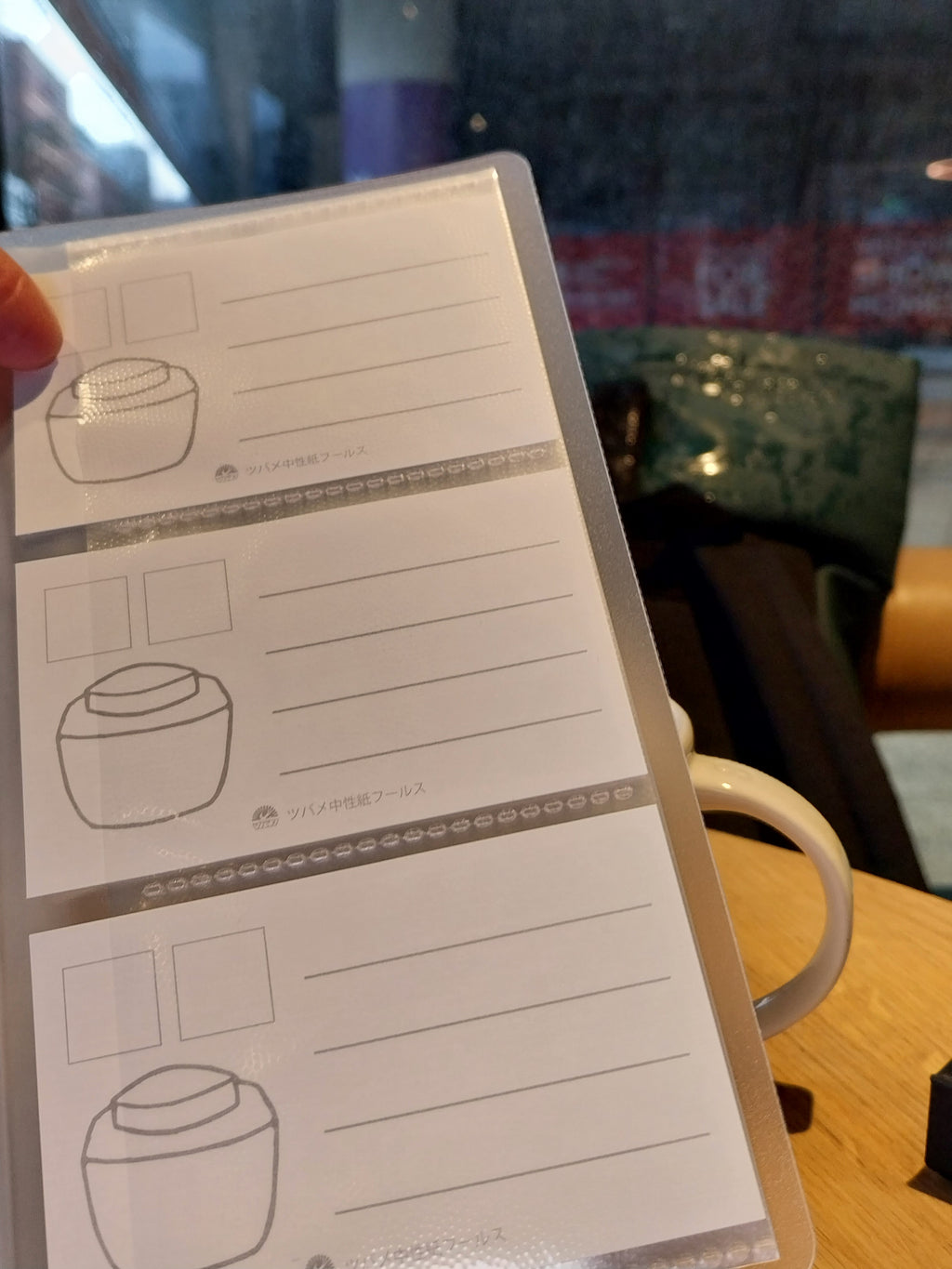 Sheet of printed templates with line drawings held by a hand in front of a blurred indoor background.